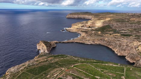 aerial view footage of inland sea in dwejra bay with fungus rock, colapsed azure window, underwater cave