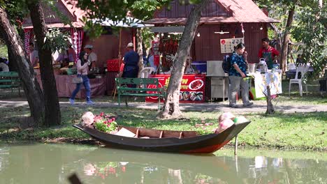 people interacting near a boat in bangkok park