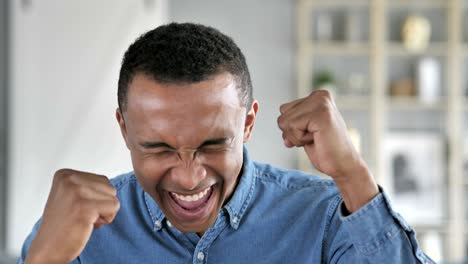 young african man celebrating success  gesture in office