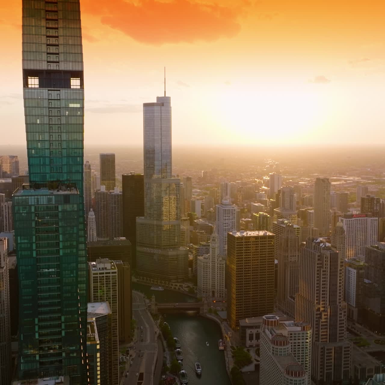 A luz alaranjada do pôr do sol refletindo nas janelas dos incríveis arranha-céus de Chicago. Panorama deslumbrante da metrópole ao pôr do sol banhado pelo sol. Vista superior