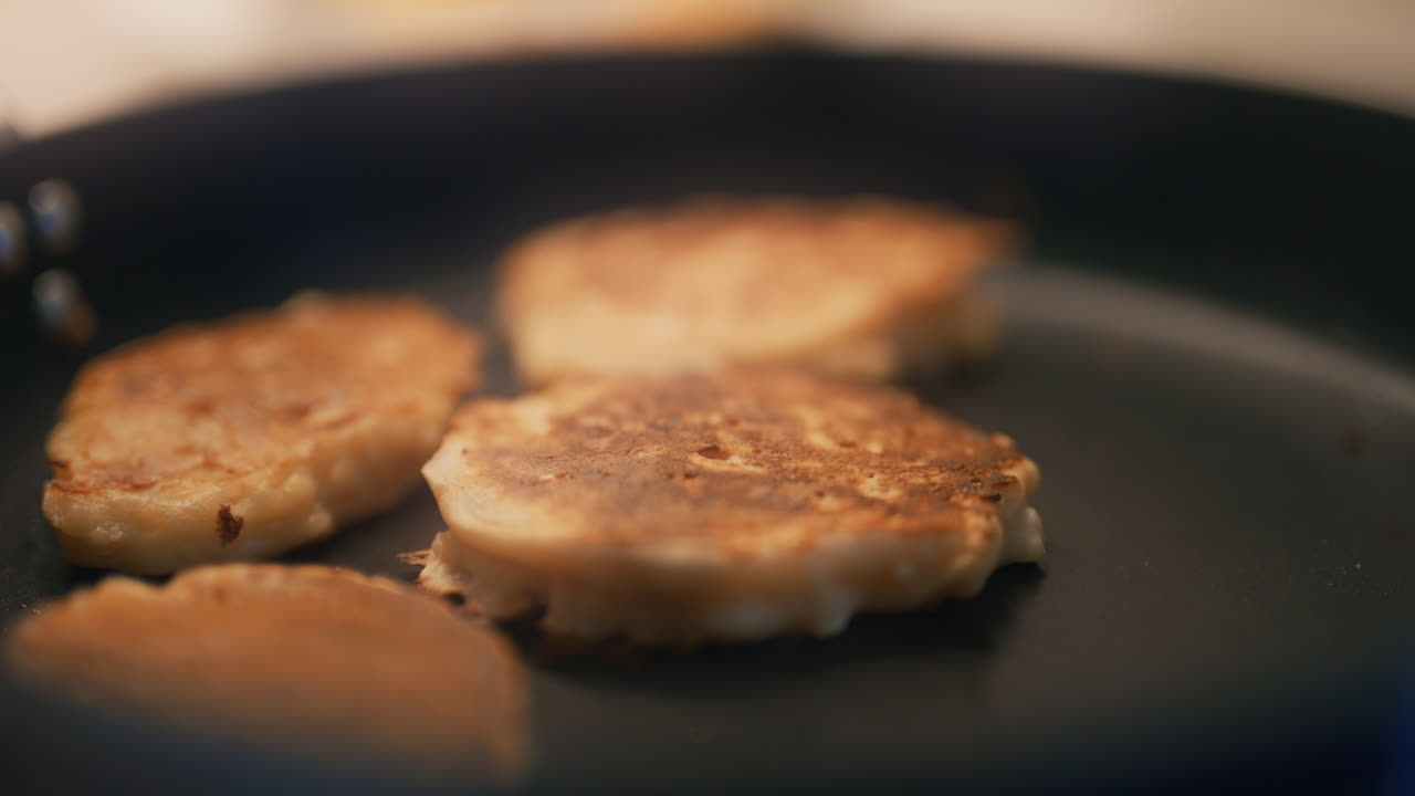 요리사는 팬에서 사과와 함께 구운 팬케이크를 수집합니다.