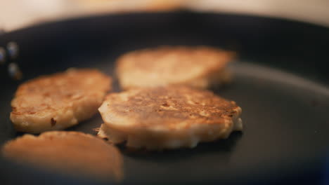 un cocinero recoge panqueques horneados con manzanas de la sartén