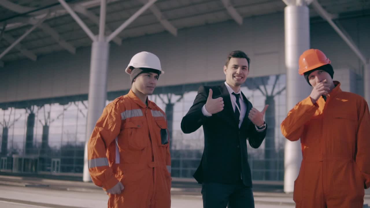 los trabajadores de la construcción y su gerente mostrando pulgares hacia arriba. el constructor, el maestro, el trabajador mostrando pulgares hacia arriba