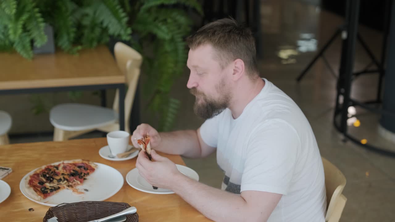 una pareja comiendo pizza en un restaurante.