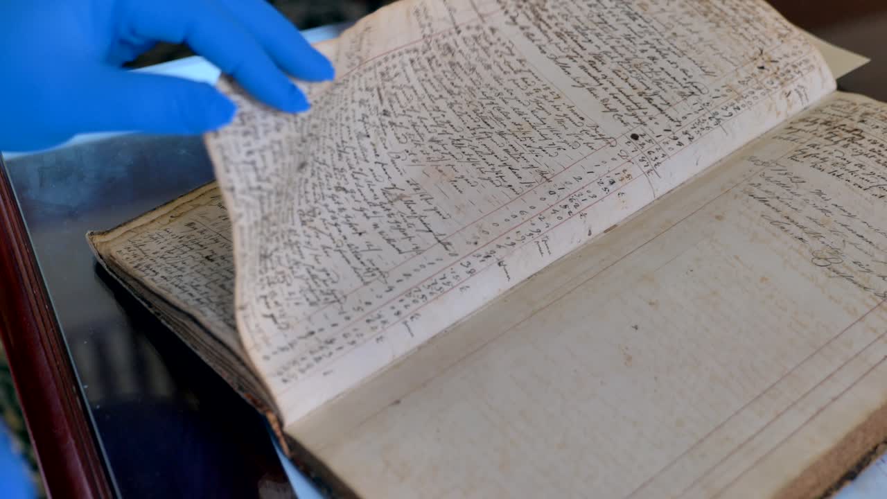 뉴욕 캐넌다이과에 있는 온타리오 카운티 연구회를 위한 역사 박물관 및 연구 도서관에서 역사적 문서 또는 골동품 장부를 보고 있습니다.