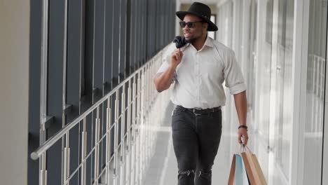 african man walking down the hall after shopping