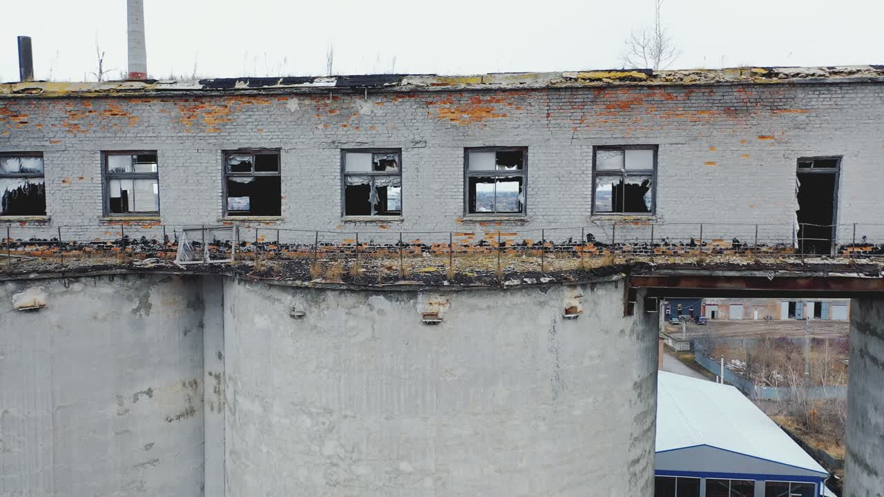Ruined building with broken windows. Very old factory. Roof with moss and grass. Aerial photography
