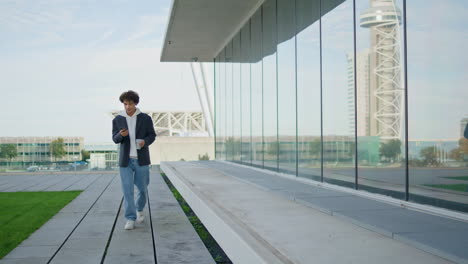 Joven-Relajado-Caminando-Solo-Por-La-Ciudad-Reflejo-De-Vidrio.-Estudiante-Sosteniendo-Cafe