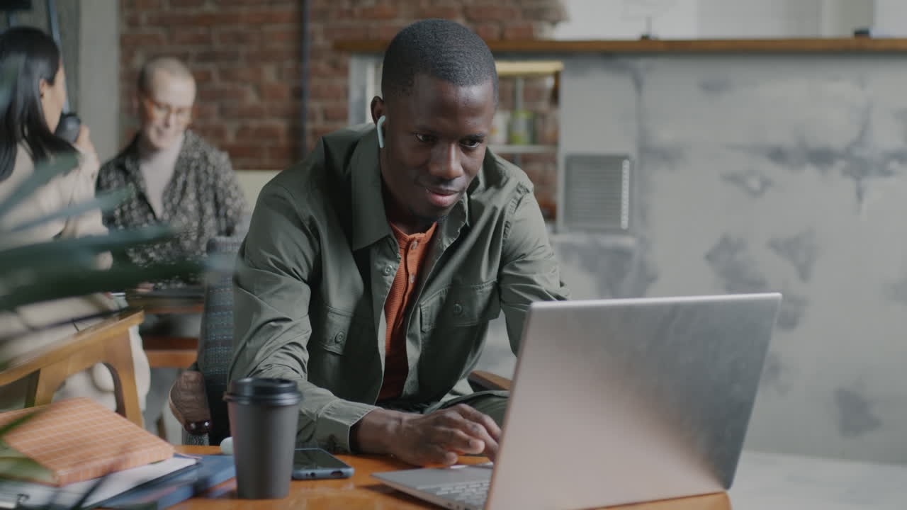 Man Working on Laptop in a Cafe