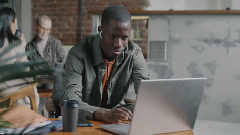 hombre trabajando en una computadora portátil en un café