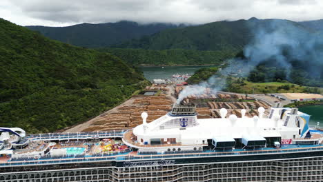 Cruise-Ship-Docked-At-Waitohi-Wharf-With-Cut-Down-Tree-Logs-In-The-Background-In-Picton,-Shakespeare-Bay,-New-Zealand