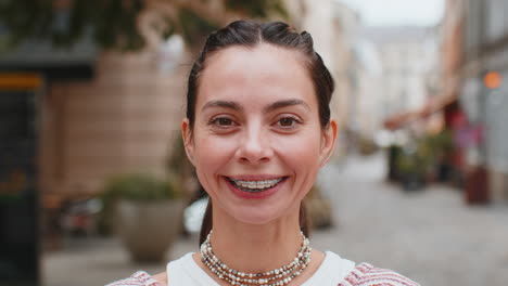 retrato de cerca de una joven caucásica feliz mostrando los dientes con aparatos ortopédicos sonriendo riendo