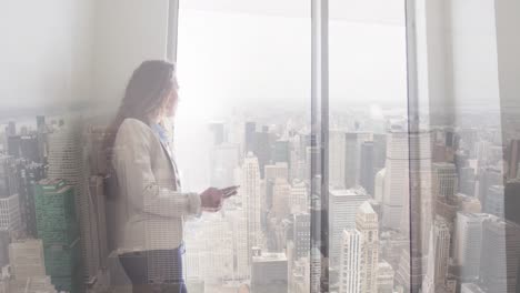 Animation-of-cityscape-over-biracial-businesswoman-in-office