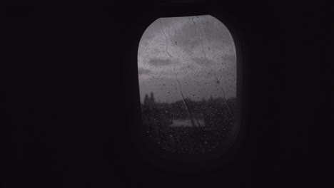 flying by plane in rainy evening view through the illuminator