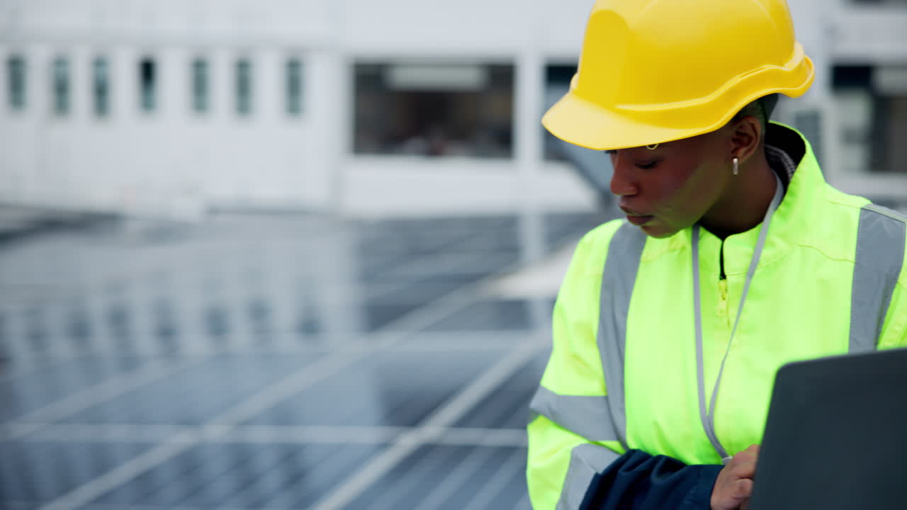 Female Engineer Inspecting Solar Panels with Laptop