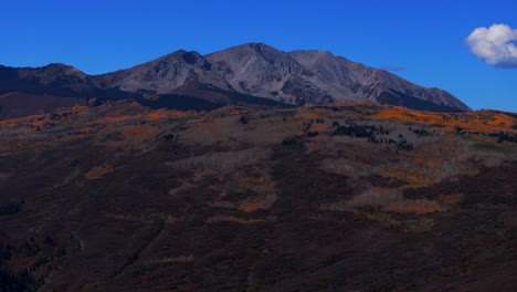mount sopris mountain valley peak from aspen old snowmass village aerial drone colorado fall autumn el jebel basalts panorama landscape foliage aspen trees forest blue sky clouds forward pan up