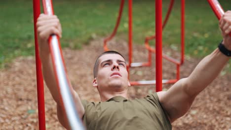 Hombre-Atlético-Haciendo-Dominadas-En-Las-Instalaciones-Deportivas-Rojas-En-El-Parque