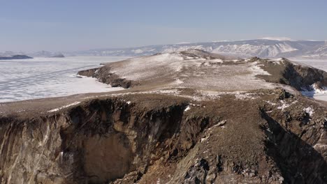 vuelo circular del dron alrededor del acantilado rocoso del helado lago baikal.