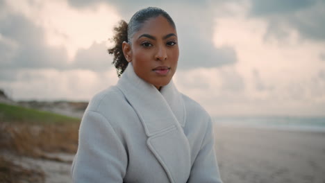 portrait de femme sérieuse regardant la caméra sur la plage de l'océan.