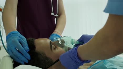 nurses wear an oxygen mask to a patient in intensive care