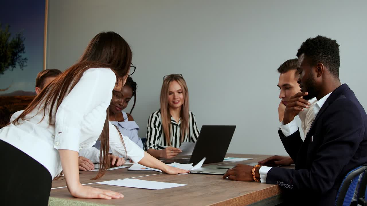 tormenta de ideas sobre la creación de su propio proyecto de criptomoneda. un grupo de personas en la oficina están discutiendo sanciones económicas. ideas creativas para el desarrollo de negocios. equipo multiétnico en la oficina en el fondo de la tabla en el proyector