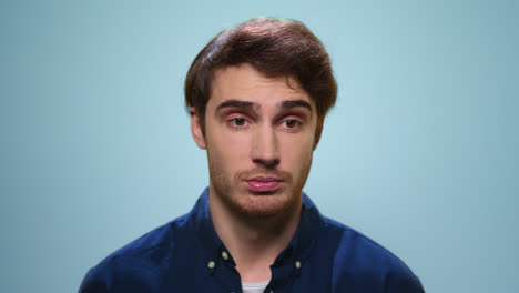 un joven masticando chicle en el estudio. un chico guapo hablando a la cámara