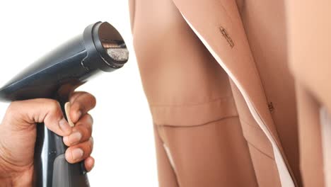 planchado a vapor de una chaqueta de traje marrón