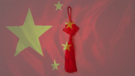 animation of flag of china over chinese traditional decorations on red background