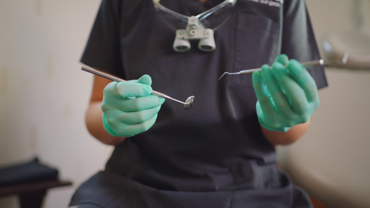 mano cercana de un dentista que sostiene herramientas para los dientes
