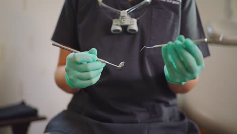 closeup hands of dentist holding tools for teeth