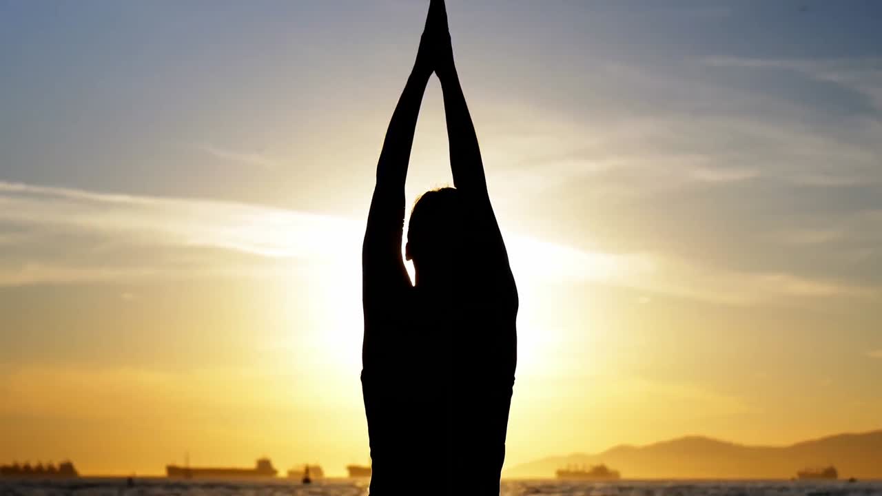 Woman performing yoga on the beach