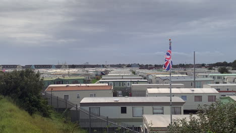 a british caravan holiday park in england with static mobile homes at the seaside with union jack flag flying