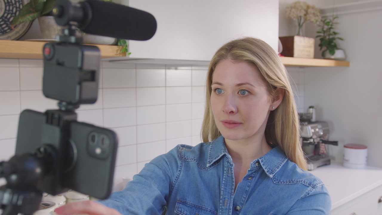 Point of view shot of woman vlogging making social media video as she carries camera around in kitchen at home - shot in slow motion