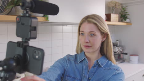 point of view shot of woman vlogging making social media video as she carries camera around in kitchen at home - shot in slow motion