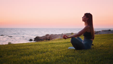 mujer meditando al atardecer junto al océano