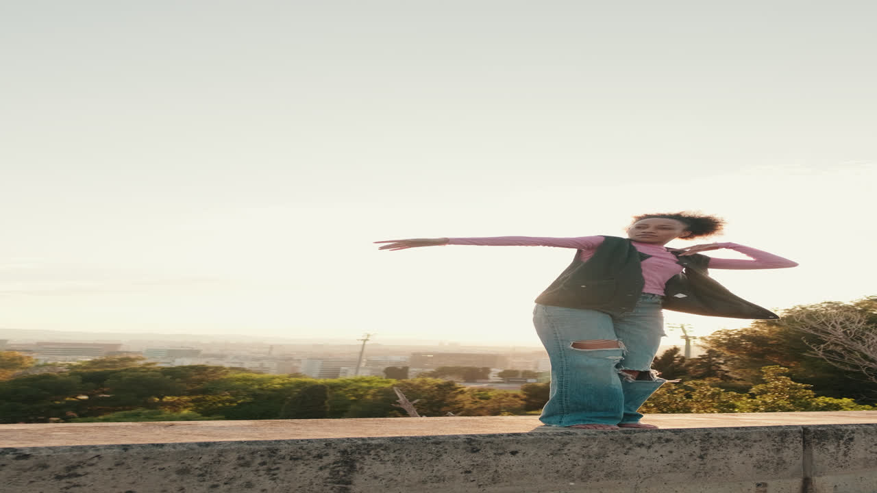 Young Woman Dances at Sunset Against Clear Sky
