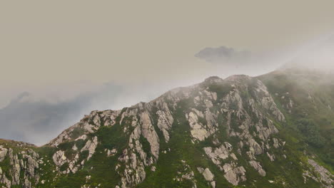 aerial view of a rocky mountain ridge, foggy day, in orobie alps, italy - tracking, drone shot