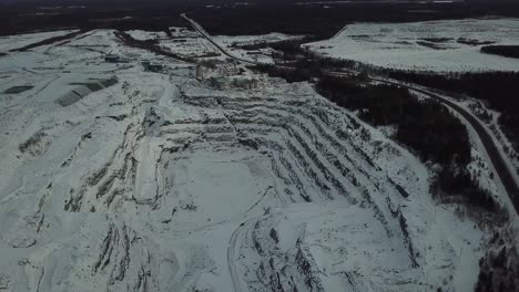 quarry and oild and gold mine hole in forest in canada pan up - drone 4k aerial