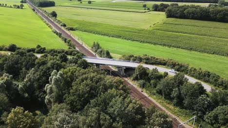 aerial view of rural landscape with road and train bridge