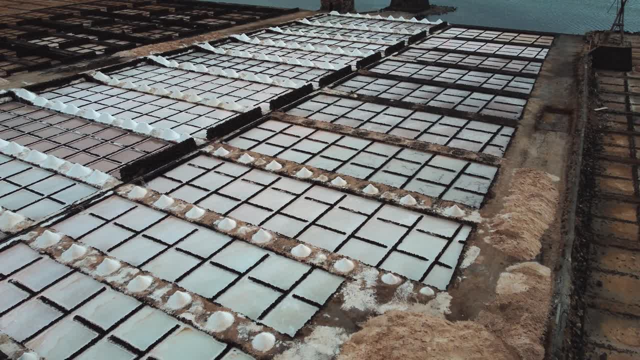 Playa de Janubio Salt Pans With Piles Of Extracted Salt. Salinas de Janubio In Lanzarote, Canary Islands, Spain. aerial tilt down