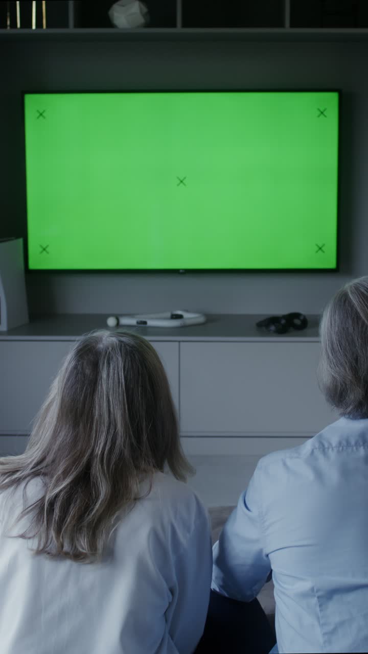 Persone che guardano la televisione con green screen
