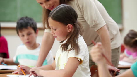 Smiling-teacher-helping-a-pupil