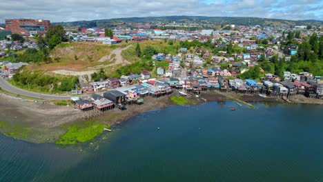 aerial orbit establishing of the stilt houses in castro, chiloé on a sunny and clear day, low tide chile