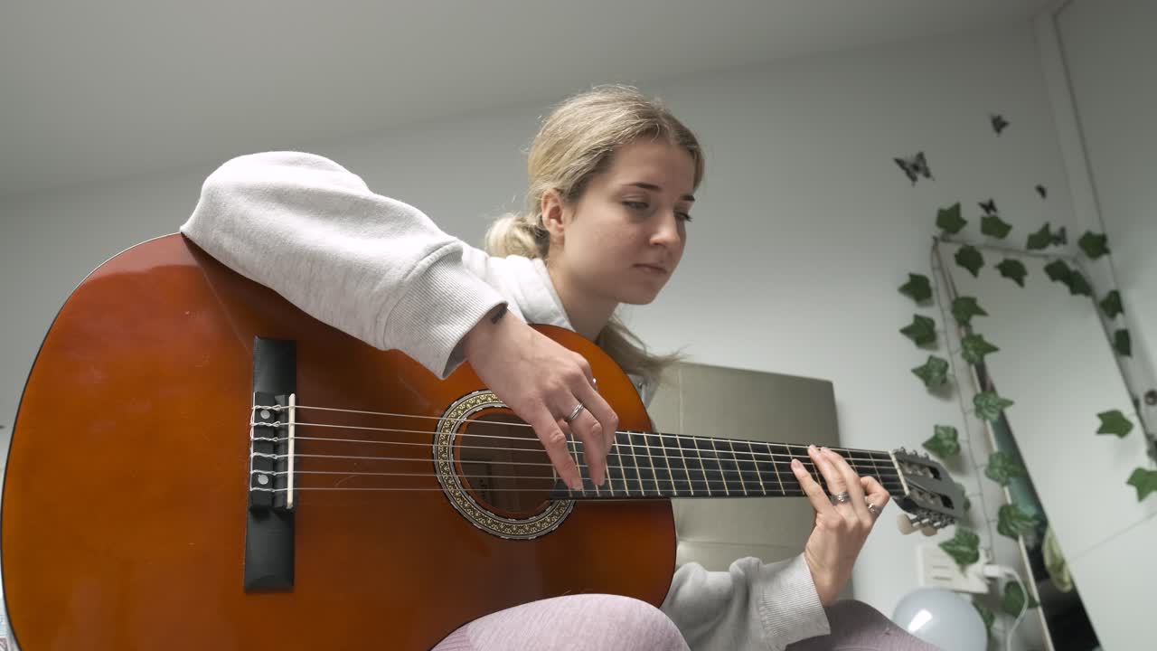 Melodic journey of a woman showcasing acoustic guitar skills in a montage