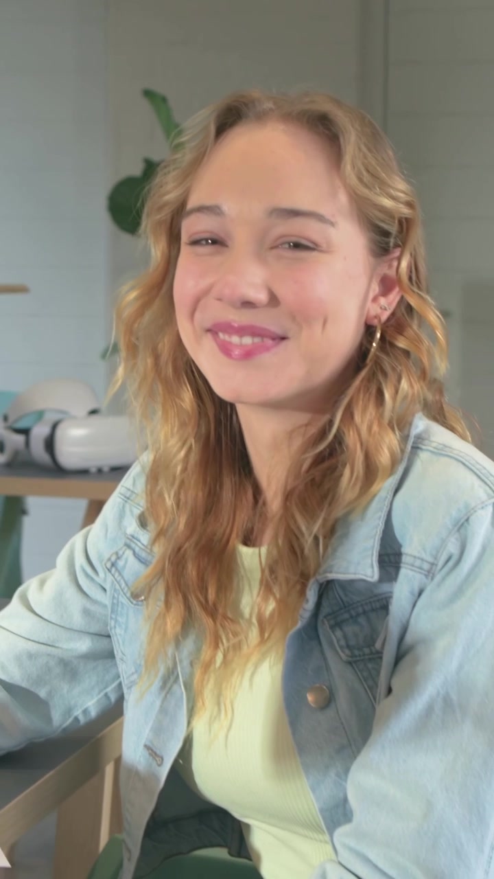 Video verticale: Donna in giacca di jeans che sfoglia pagine, seleziona campioni e sorride alla telecamera in studio.
