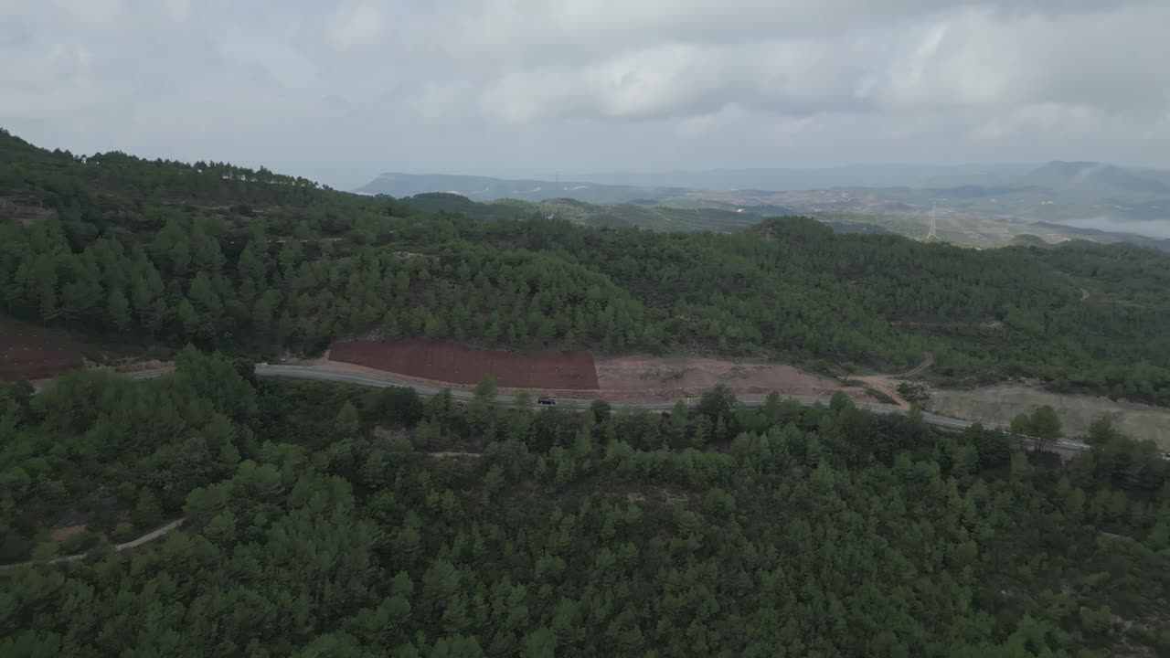 vista aérea de la carretera y el bosque en las montañas de montserrat con pinos y niebla