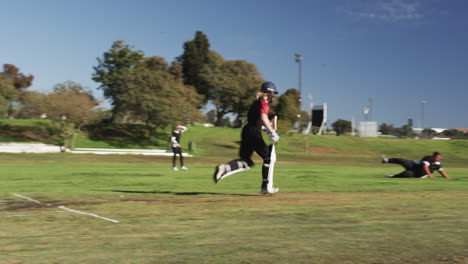 Playing cricket, female athlete running on field during daytime match