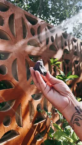 woman holding amethyst and ruby crystals outdoors