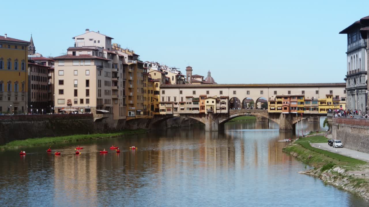 Kayakistas reman en el río Arno con el histórico Puente Vecchio en Florencia, Italia