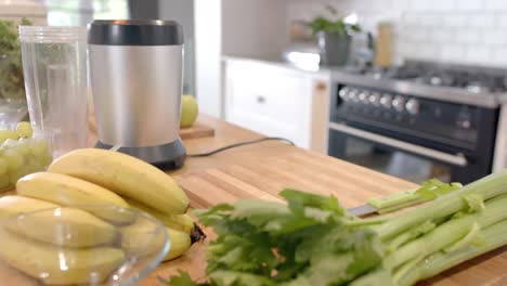 Vegetables-and-fruits-with-kitchen-equipment-on-countertop-in-kitchen-at-home,-slow-motion